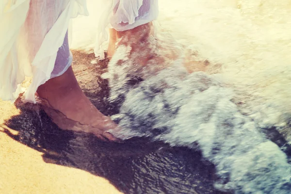 Imagen de los pies en una playa y el agua . —  Fotos de Stock