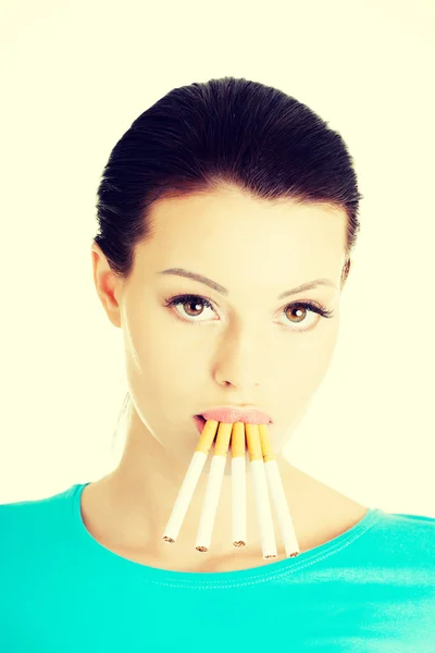 Молода красива жінка з цигарками в роті . — стокове фото