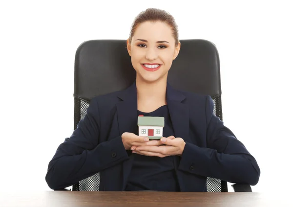 Happy real estate agent, holding a house model — Stock Photo, Image