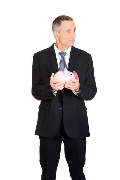 Homem de negócios segurando piggybank — Fotografia de Stock