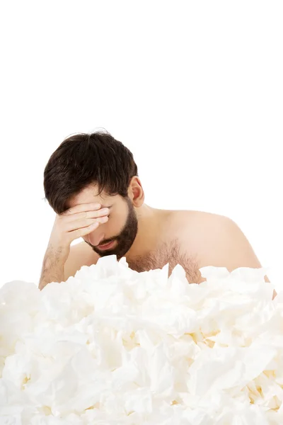 Homem doente sentado com um monte de tecidos . — Fotografia de Stock