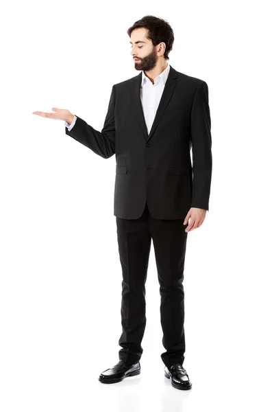Young businessman showing empty copyspace on hand. — Stock Photo, Image