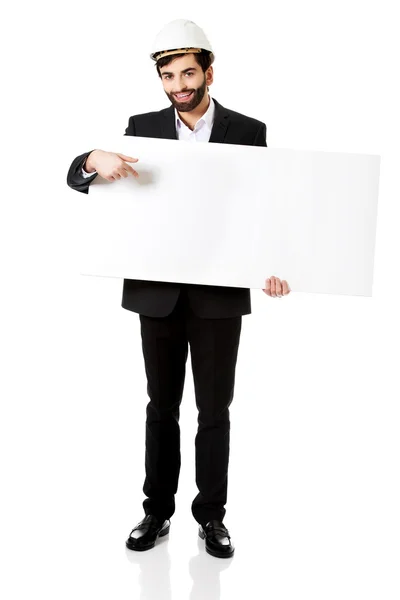 Engineer in helmet pointing on empty banner. — Stock Photo, Image