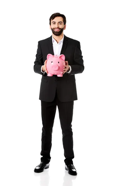 Empresário que detém um Piggy Bank. — Fotografia de Stock
