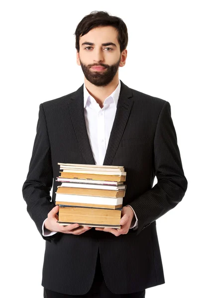 Молодой бизнесмен держит стопку книг . — стоковое фото