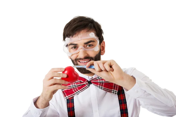 Determined man cutting heart model with scalpel. — Stock Photo, Image