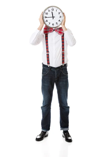 Man wearing suspenders hiding behind big clock. — Stock Photo, Image