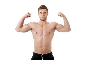 Kaslarına gösterilen genç atletik erkek.