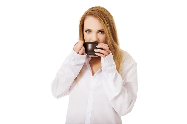 Frau im langärmligen Hemd trinkt Kaffee. — Stockfoto