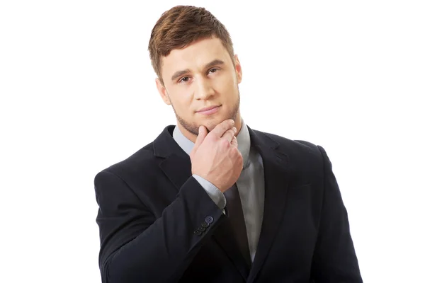 Successful businessman with finger under chin. — Stock Photo, Image