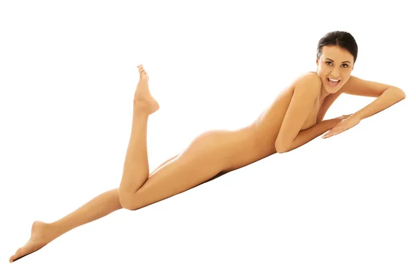 Naken kvinna liggande på mage med ena benet — Stockfoto