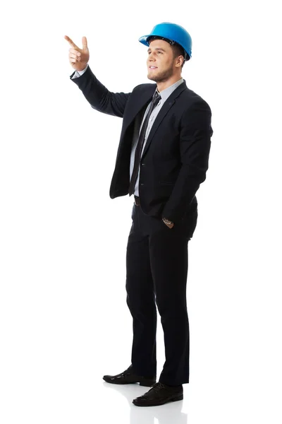 Happy businessman in helmet points his finger up. — Stock Photo, Image