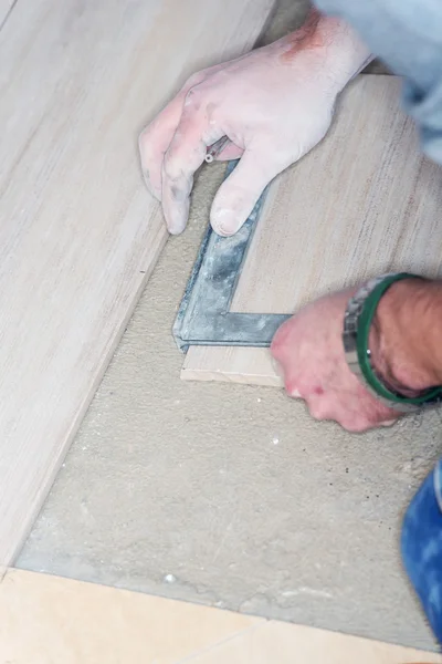 Tiler installs ceramic tiles — Stock Photo, Image