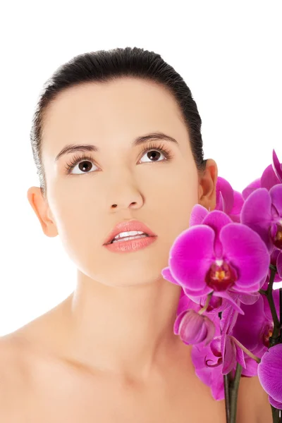 Mulher com galho de orquídea roxa — Fotografia de Stock