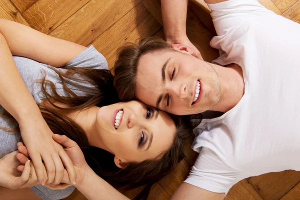 Casal feliz deitado no chão . — Fotografia de Stock