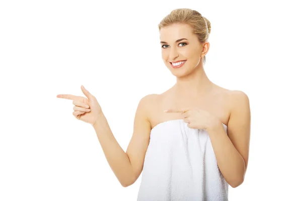 Woman in towel pointing to the left. — Stock Photo, Image