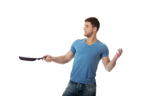 Muscular man holding frying pan. — Stock Photo, Image