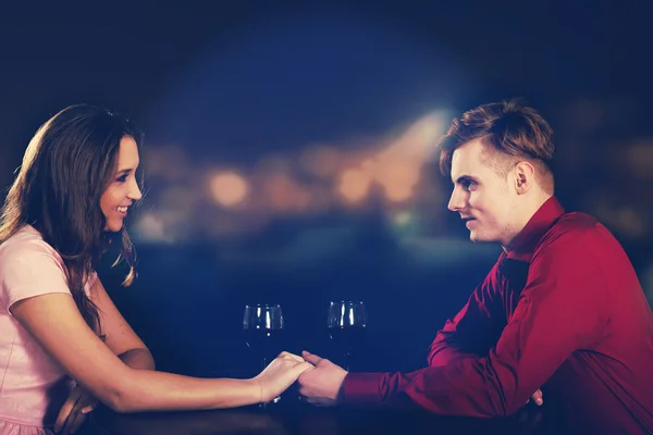 Couple with wine by a table. — Stock Photo, Image