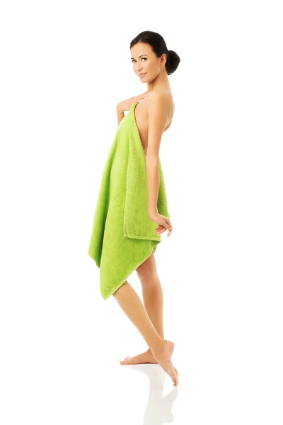 Vista lateral mulher de pé envolto em toalha — Fotografia de Stock