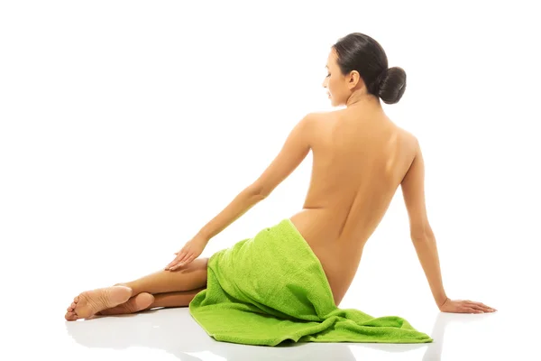 Bakifrån kvinna sitter insvept i handduk — Stockfoto