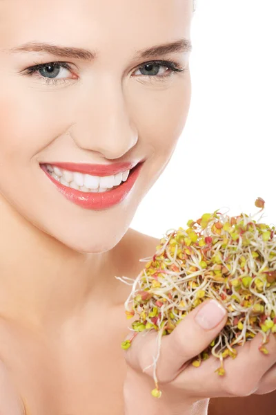 Close up nude woman holding sunflower sprouts — Stock Photo, Image