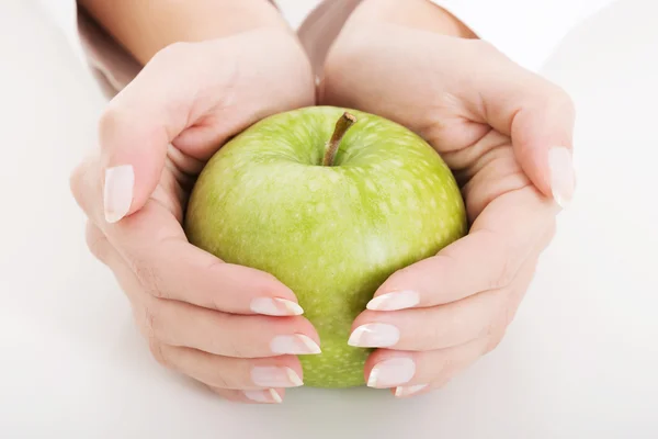 Großer grüner Apfel in den Händen Stockbild