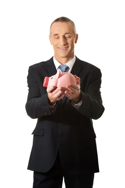 Feliz hombre de negocios sosteniendo Piggybank — Foto de Stock