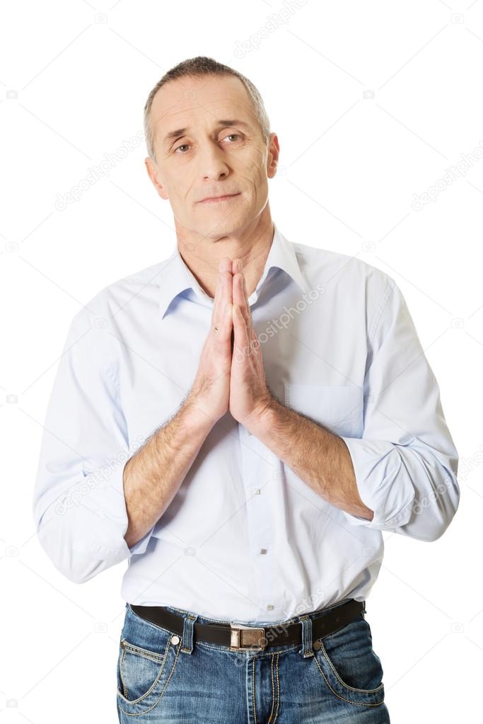 Mature man praying to God