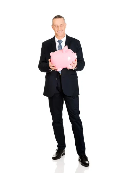 Веселый бизнесмен держит копилку — стоковое фото