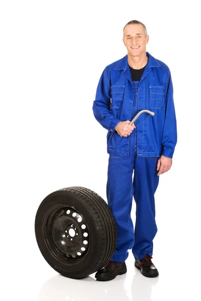 Mechanic with a tire and wrench — Stock Photo, Image