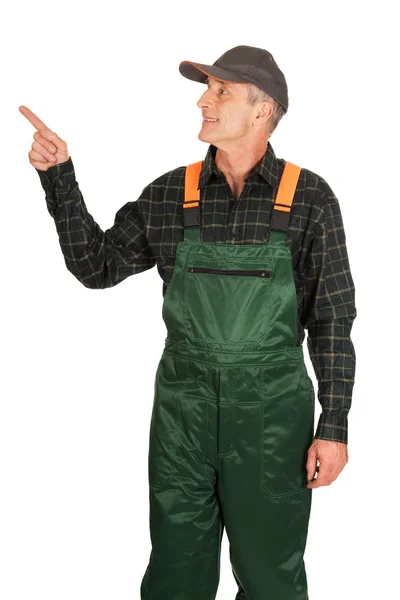 Mature gardener in uniform pointing up — Stock Photo, Image