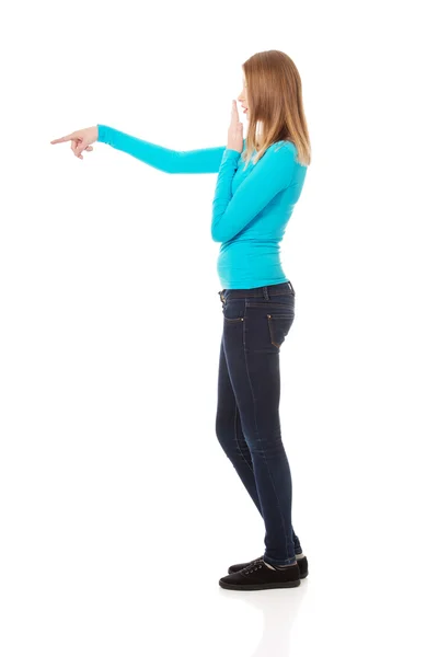 Mujer sorprendida señalando a la izquierda — Foto de Stock