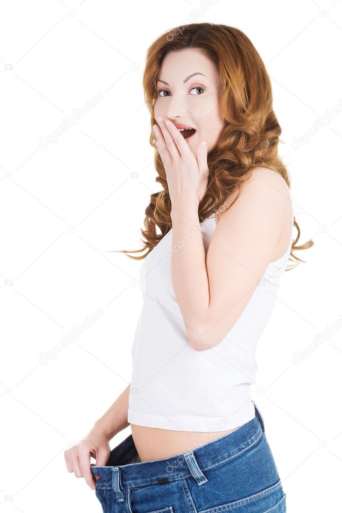 Surprised woman in too big jeans