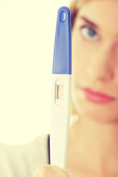 Sad woman holding pregnancy test — Stock Photo, Image