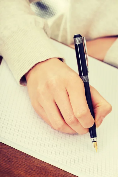 Mão escreve com uma caneta em um caderno — Fotografia de Stock