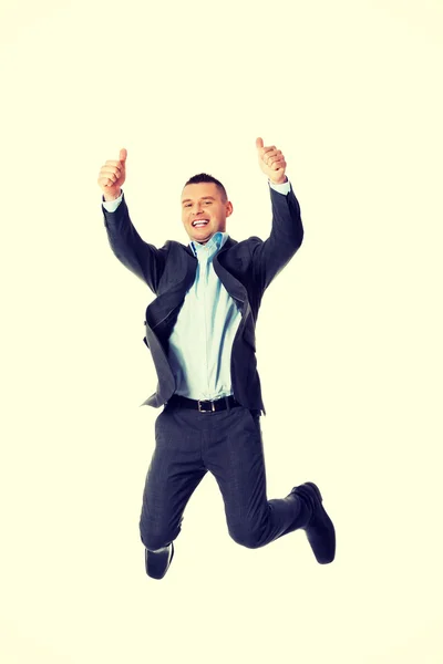 Businessman jumping with thumbs up — Stock Photo, Image