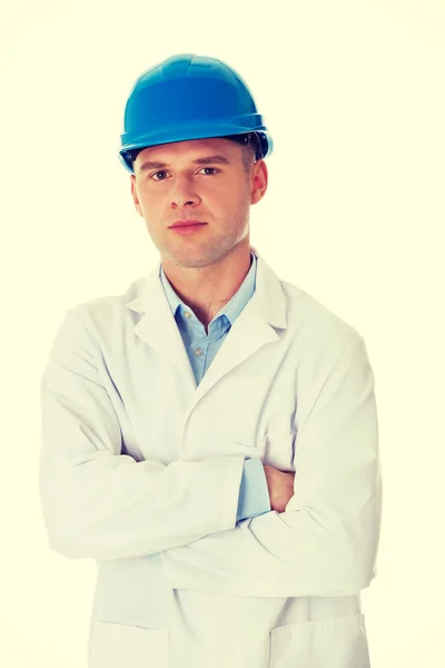 Hombre con una bata de laboratorio y casco —  Fotos de Stock