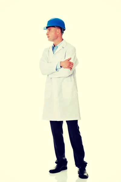 Man in a lab coat and helmet — Stock Photo, Image