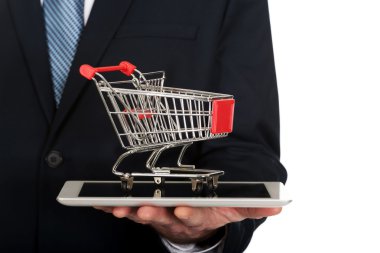Alışveriş sepeti tablet üzerinde tutan işadamı