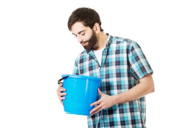 Yakışıklı adam kova içine bakan.