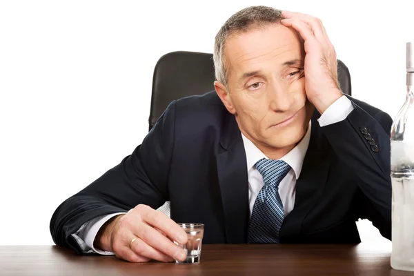 Hombre sobrecargado de trabajo bebiendo vodka en la oficina —  Fotos de Stock