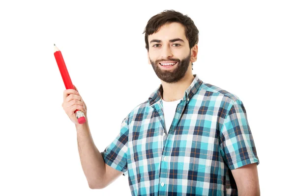 Hombre sosteniendo un lápiz rojo grande . — Foto de Stock