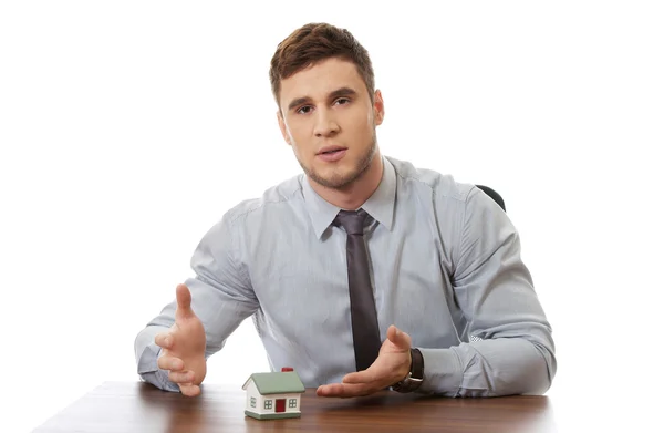 Businessman with house model at the desk. — Stock Photo, Image