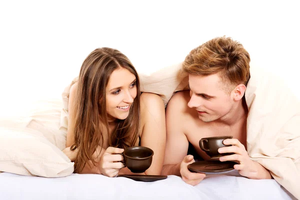 Mutlu çift yatakta kahve içme. — Stok fotoğraf