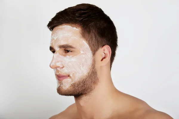 Man with cream moisturizer on his face. — Stock Photo, Image