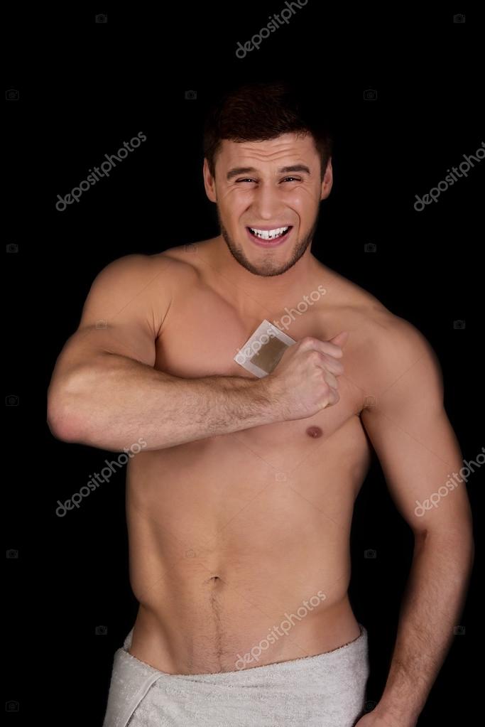 Handsome man waxing his chest. — Stock Photo © piotr_marcinski 65210487