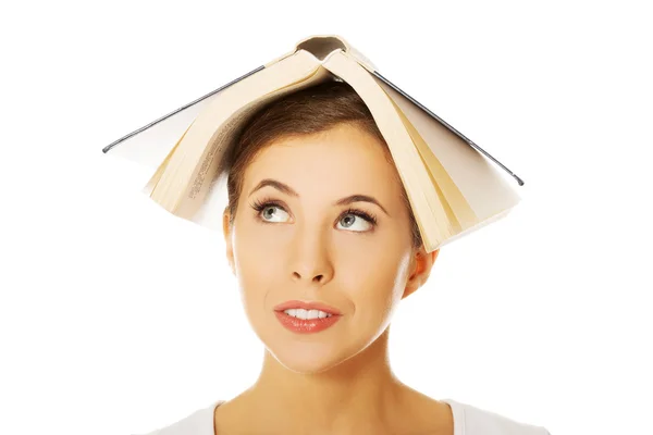 Mulher segurando livro na cabeça — Fotografia de Stock