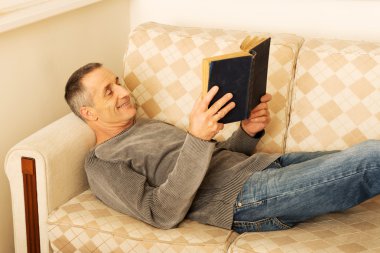 Olgun adam evde kitap okurken