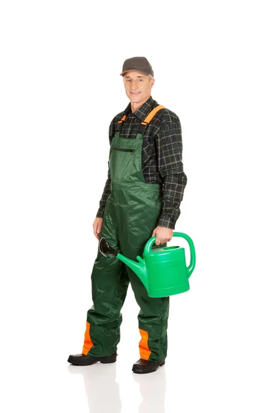 Workman holding green watering can — Stock Photo, Image