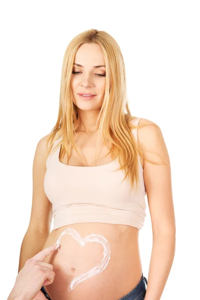 Man tillämpar en kräm på gravid mage — Stockfoto